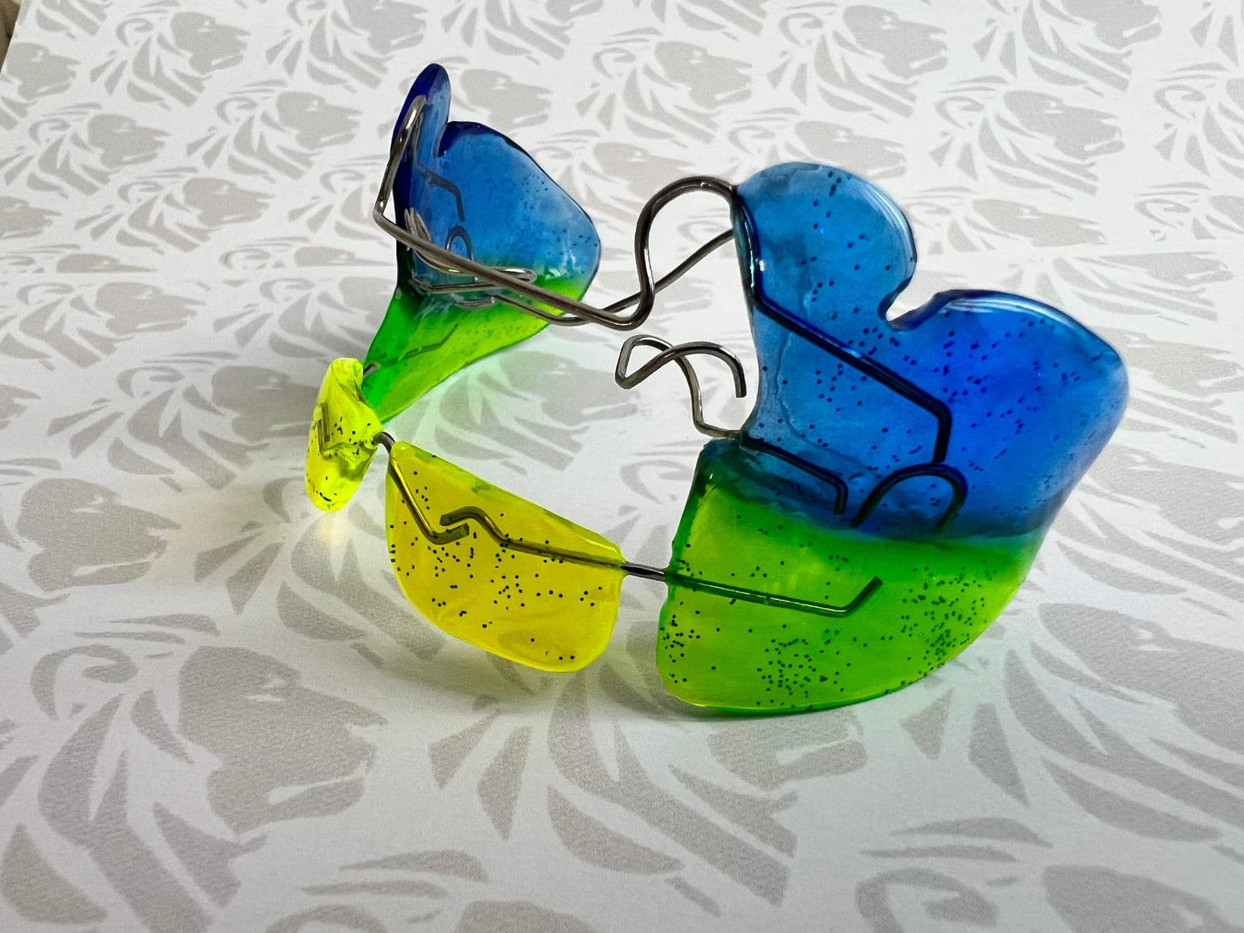 Apparecchio funzionale in resina blu, verde e gialla con glitter